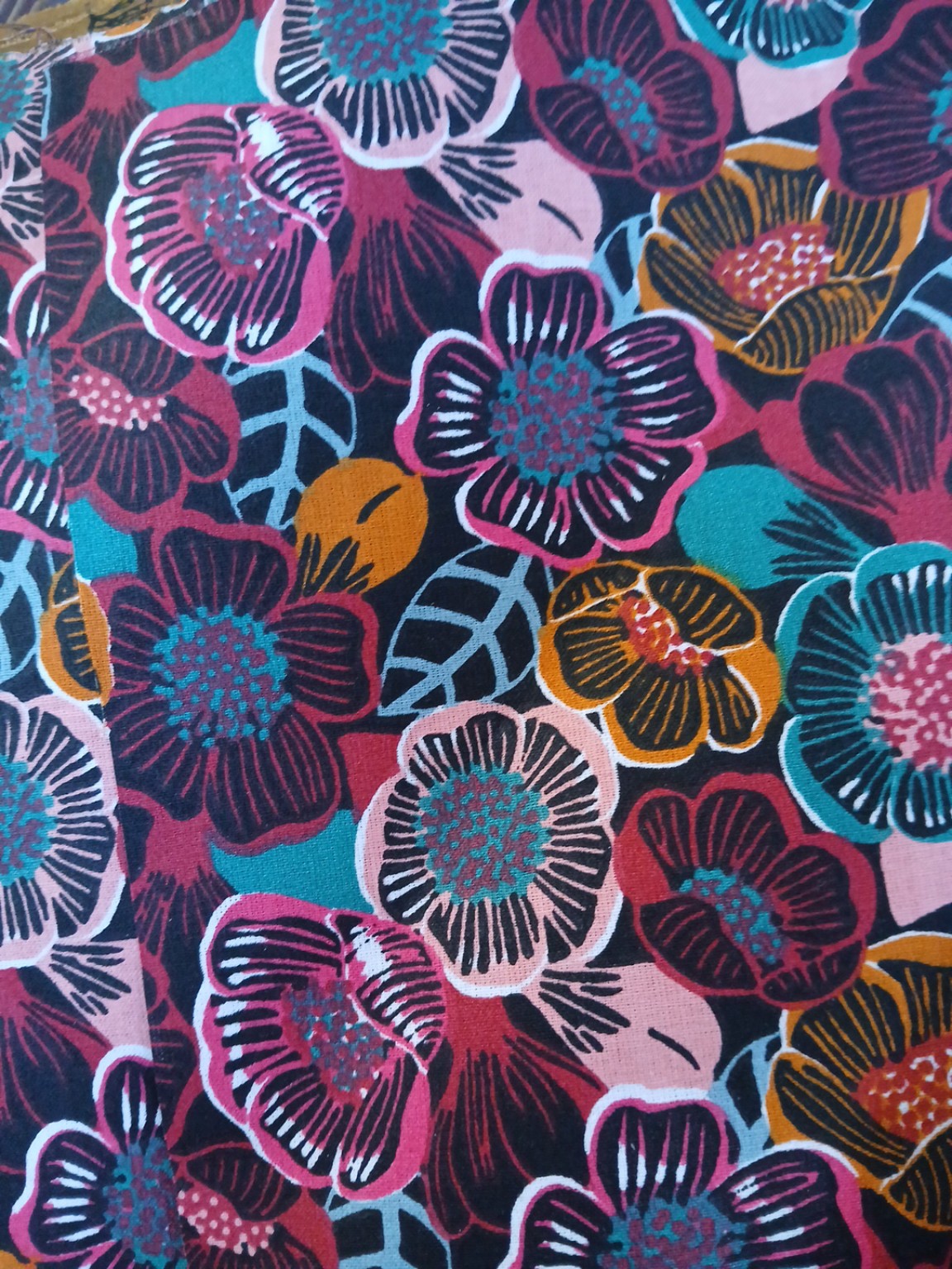 Éventail Freya fait main en tissu floral graphique aux tons rose, ocre et turquoise, inspiré de la déesse nordique de l’amour