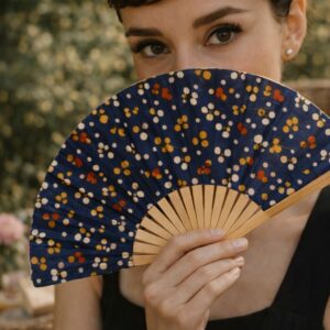 Femme élégante tenant un éventail Audrey bleu nuit à motifs délicats
