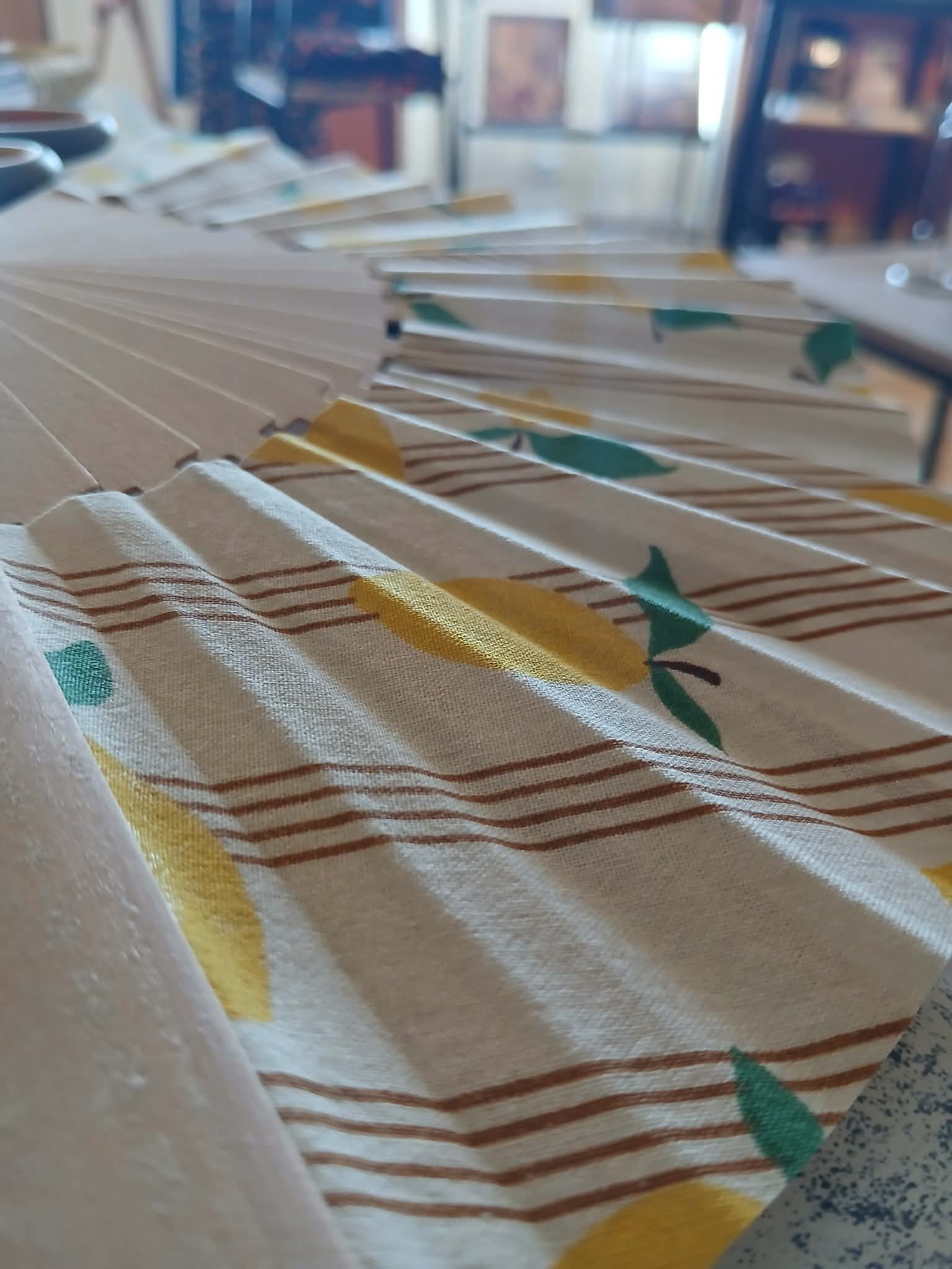 Éventail citron tenu à la main, gros plan sur le motif